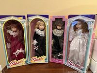Four Classic Collection ceramic dolls in original boxes, showing front view of dolls and packaging
