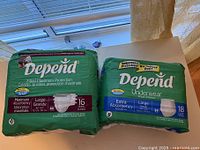 Photo of two packages of Depend adult diapers, large size, highlighting absorbency levels and counts.