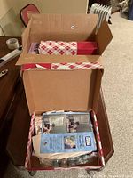 Open box showing the interior with the painting kit and paint jars visible under brochure.