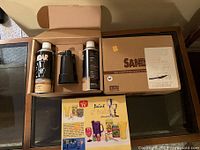 Kit with two aerosol paint cans, black plastic compressor, and instruction booklet boxed