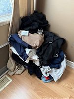 Pile of assorted used clothing including sweaters and sweatshirts in various colors and fabrics