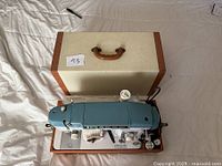 Sewing machine on base in open hard case
