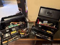 Photo showing two open metal toolboxes containing various vintage tools and supplies.