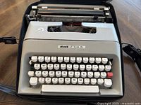Front view of the vintage Olivetti Lettera 35 typewriter showing keyboard and part of carrying case