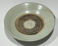 Top view of the stoneware Celadon plate showing the thick curd-like glaze and unglazed inner band.