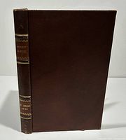 Front cover shows dark brown leather binding with gilt title and author name on spine.