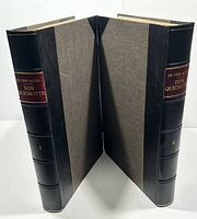 Two matching hardcover antique volumes with leather spines and cloth covers.