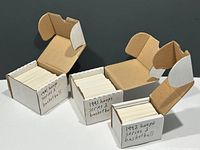 Three small cardboard boxes containing stacks of NBA Hoops basketball cards from the early 1990s, each box labeled with series and year.