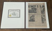 Folio opened showing the newspaper with the headline 'KENNEDY IS SLAIN' alongside the certificate of authenticity mounted inside.