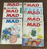 Top view of 8 Mad Magazine issues showing colorful illustrated covers from 1975-1979 in a stacked arrangement.