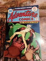 Front cover of Adventure Comics #438 showing title, price, date, and cover artwork depicting a woman held by creatures.
