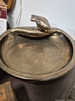 Ceramic bird bath with small bird figure on edge
