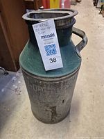 Tall vintage metal can with green top and silver body. Has two metal handles and embossed 'CC CO-OP' on its body.