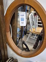 Photo of the oval wooden framed mirror hanging, showing the shape and wood grain.