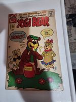 Front cover of Yogi Bear Comic #10 showing cartoon bears, honey jar, and comic title with price 20 cents. Visible three-hole punches along left binding side and wear to edges.