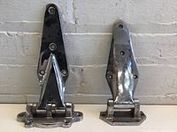 Front view of two antique chrome plated fridge hinges, one large Kason forged brass hinge (left), one smaller unbranded hinge (right).