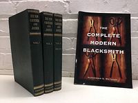 Four books: The Complete Modern Blacksmith paperback and three volumes of The New Carpenter and Joiner hardcover.