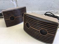 Close-up of two ultrasonic pest repeller units with grills and power cords visible.