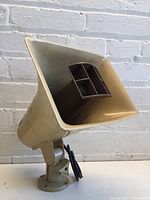 View of entire Valcom speaker horn unit mounted on base, showing overall shape, color, and surface condition with repairs.