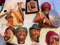 Photo showing six Bosson Heads with various male characters and one partially visible figure of a man holding a shield.