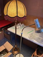 Full view of vintage floor lamp with yellow fabric lampshade and attached directional lamp