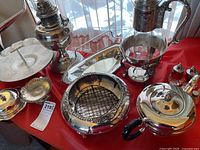 Overall view of the serveware set including hurricane lamp, trays, decanter, tea pot, and salt and pepper shakers