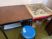 Front view showing black and red square-top tables with blue stool positioned between