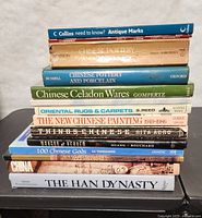 Photo of stacked books showing all titles and publishers, including topics on Chinese pottery and art history