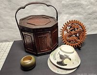 Photo of the wooden dragon plaque, antique bamboo basket with cracked handle, small ceramic vase, and two hand painted chicken bowls.