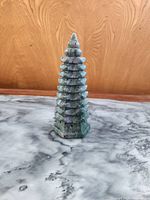 Full frontal view of the pagoda tower showing the tiered structure and mottled green stone texture