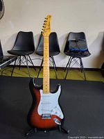 Full front view of guitar showing sunburst body, white pickguard, neck and headstock