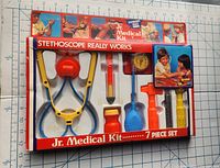 Full view of vintage Jr. Medical Kit 7 piece set in original packaging showing stethoscope and other medical toy instruments.
