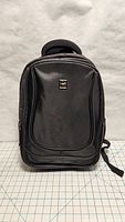 Front view of black Polo Sport backpack on grid background to display size and details.