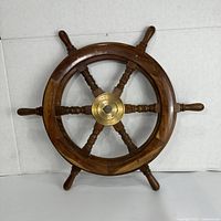 Front view of the wooden steering wheel with six spokes and brass center.