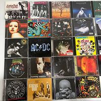 Photo shows 20 CDs with various band art including Linkin Park, Ramones, AC/DC, Rob Zombie, and Chevelle.