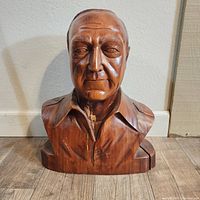 Frontal view of the large wooden bust showing facial features and collar.