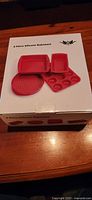 Box front showing image and label of 4 piece silicone bakeware set in red.