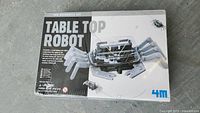 Front of the 4M Table Top Robot Kit packaging showing the assembled crab robot and branding.