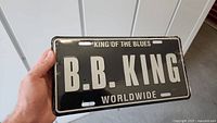 Front side of a black metal license plate with white print showing 'B.B. King Worldwide' and 'King of the Blues'