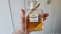 Front view of the Chanel N°5 Paris Eau de Parfum bottle showing label and amber liquid approximately half full.