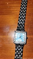 Front view of the Jewel women's silver color watch showing blue face, jeweled square bezel, and linked metal bracelet.