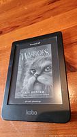 Front view of Kobo Clara HD e-reader showing the book cover Warriors Rising Storm by Erin Hunter on the screen.