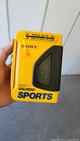 Front view of yellow Sony WM-AF54 Walkman showing cassette window, brand, and radio frequency display