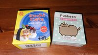 Front view of two magnet boxes: Sushi Cats and Pusheen sets
