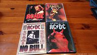 Front view of four AC/DC DVDs showing cover artwork with band members and concert images.