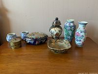 View showing all seven ceramic items arranged on a flat surface with a plain wall background