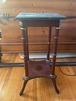 Front view of the wooden stand showing square marble top and four legs.