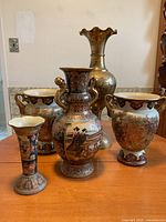 Front view of entire vase collection on wooden table showing five distinct vases with varied sizes and ornate hand-painted decorations in traditional Japanese style.