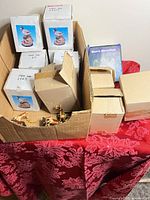 overall view of carton with boxed figurines, ornaments, clock