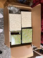 Cardboard shipping carton with five retail figurine boxes visible